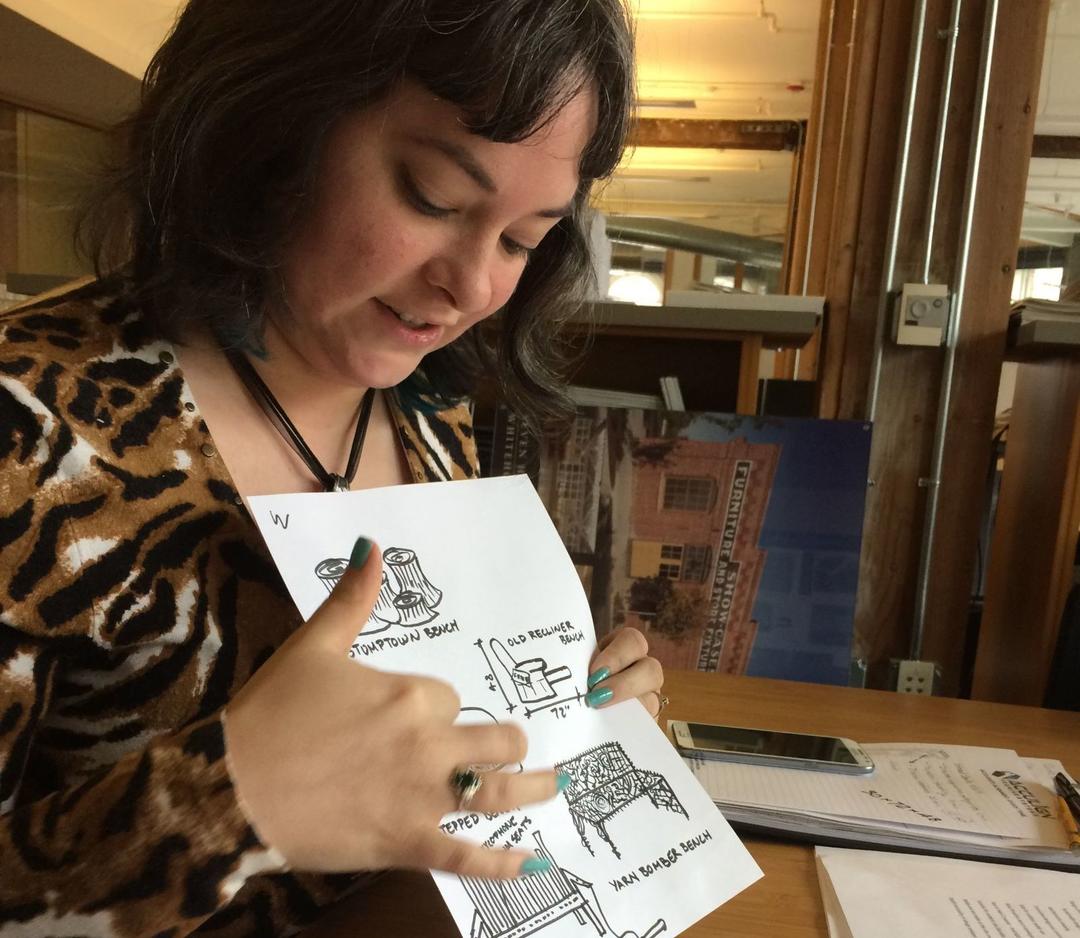 Ellen Krusi pointing to design sketches on a piece of paper