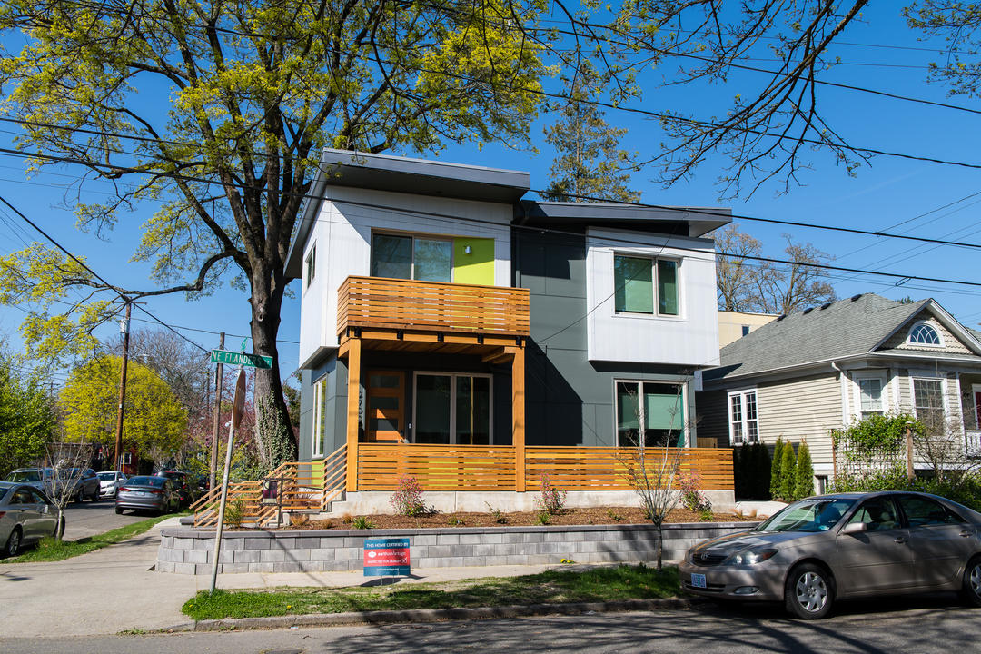 Thoughtful urban infill two-story duplex on a corner lot. A large maple tree shades the homes.